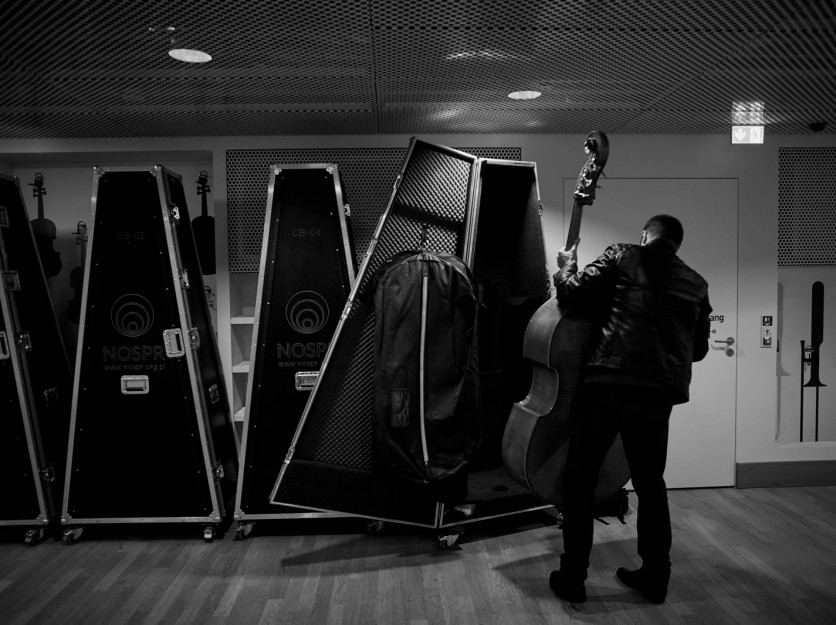 NOSPR musician taking a double bass out of its case.
